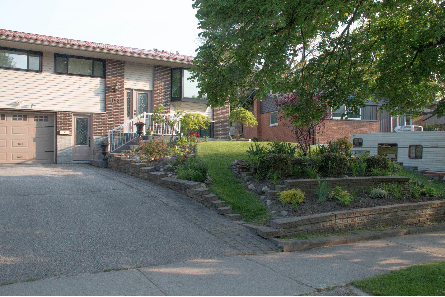 A brown two story home with a detailed front garden in Kitchener Ontario